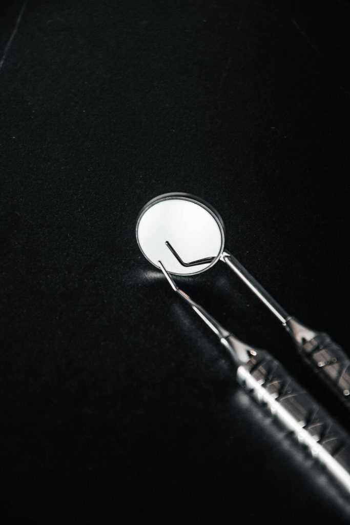 Espejo dental sobre fondo negro.